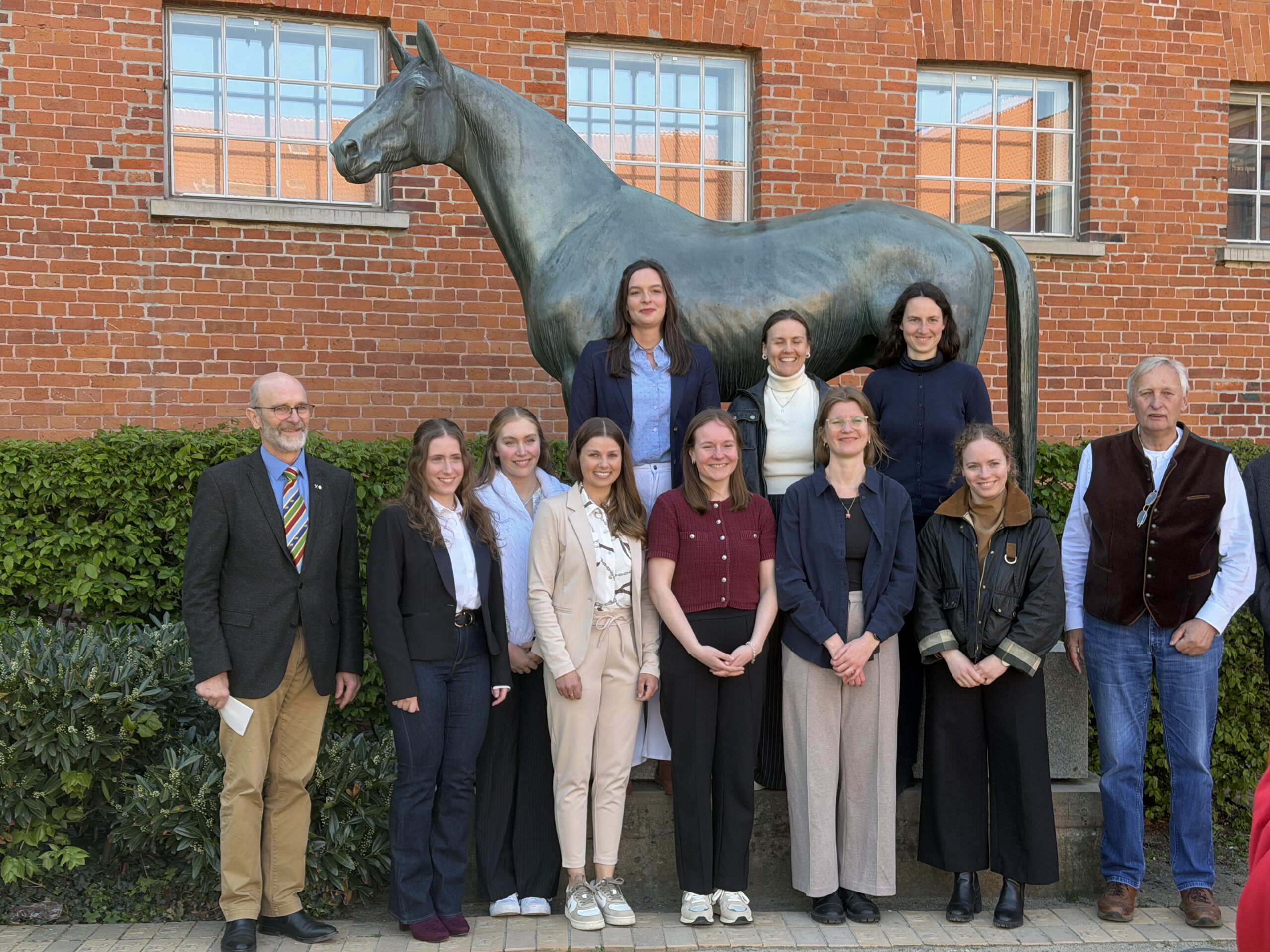 Vor dem Tempelhüter-Denkmal in Verden: Die Autorinnen aller 2026 von der GWP prämierten Arbeiten, flankiert vom GWP-Vorsitzenden Dr. Ludwig Christmann (li.) und Jury-Mitglied Hendrik Fiegel.